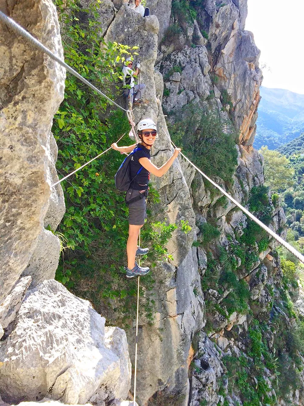 Woman crossing a via ferrata cable bridge