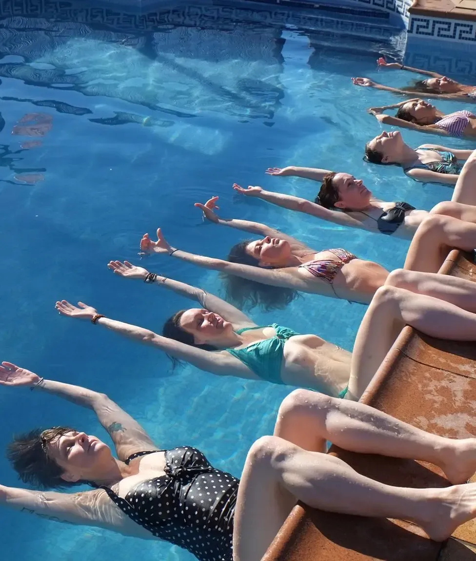 A line of women floating in the pool at Suryalila
